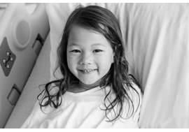 Young Girl Smiling in Hospital Bed