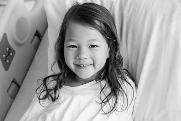 Young Girl Smiling in Hospital Bed