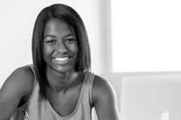 Teenage Girl Sitting By Computer Smiling