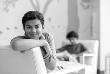 Middle School Aged Boy Leaning Over Chair