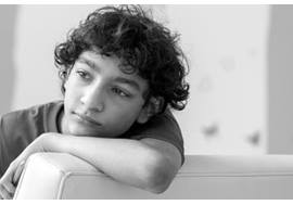 Reflective Teen Boy Resting Arm on Chair