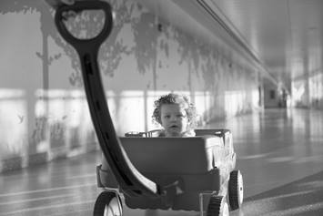 Toddler girl in red wagon 