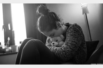 Teenage girl hugging a teddy bear