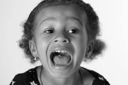 Child opening mouth wide for tonsillectomy check.