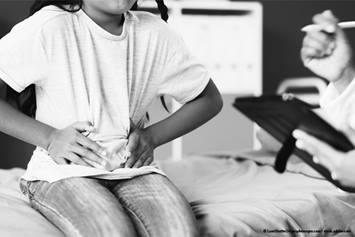 child holding their stomach in pain