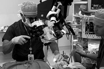 Physician performing ear tube surgery on a child.