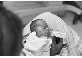 newborn with a bottle in their mouth