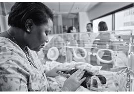 Nurse tending to a baby in the small baby program